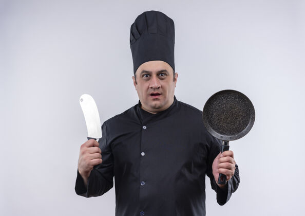 油炸穿着厨师制服的中年男厨师手拿煎锅和切肉刀厨师切肉刀厨师