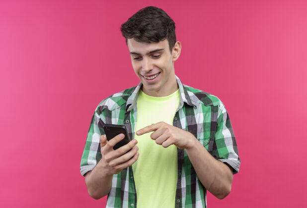 衬衫微笑的白人年轻人穿着绿色衬衫拨打电话号码在孤立的粉红色背景绿色穿着微笑