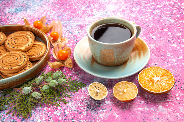 茶碟前视图甜饼干美味的小饼干与酸浆和茶在淡粉色的桌子上马克杯饮料蛋糕
