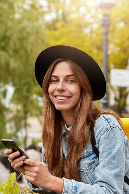 技术快乐欧洲女人微笑外景 手持现代手机 查看邮箱 享受阳光 短信阅读手机小工具