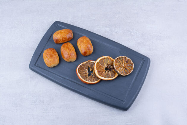 切片自制糕点 深色盘子上放着橘子干橙子糕点甜点