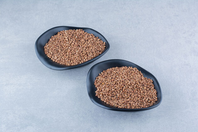 谷物在大理石背景上 荞麦籽堆在两个碗里荞麦碗健康