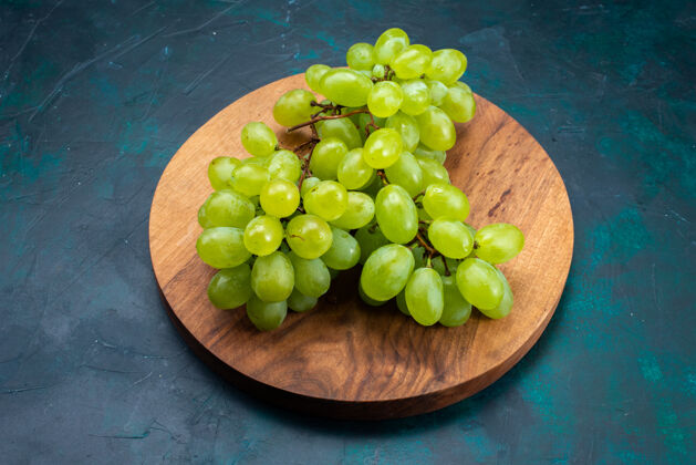 深蓝色半顶视图新鲜的绿色葡萄醇厚多汁的水果在深蓝色的桌子上一串水果葡萄藤