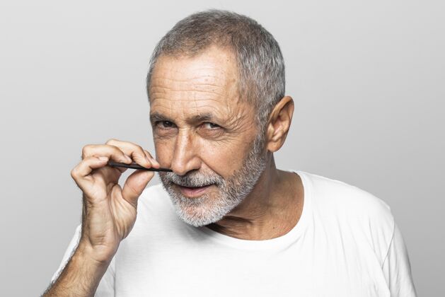 老年人特写男子手持面部工具护理男性男人