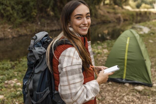 旅行快乐的野营女孩在森林和帐篷的高视野假日自然体验