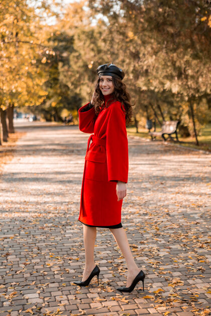 装束迷人时尚的微笑瘦削女子卷发漫步公园穿着温暖的红色外套秋季时尚 街头风格 戴贝雷帽配饰夹克优雅
