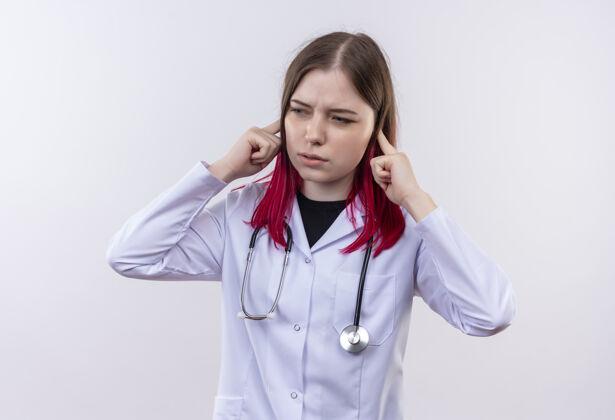 医疗看着身边年轻的女医生穿着听诊器医用长袍闭着耳朵在孤立的白色背景下听诊器侧封闭