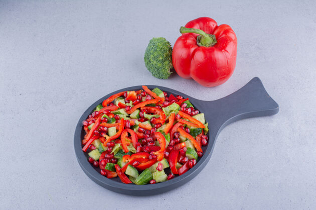 蔬菜一小锅蔬菜沙拉 旁边是一个甜椒和一个大理石背景的花椰菜美味饮食美味