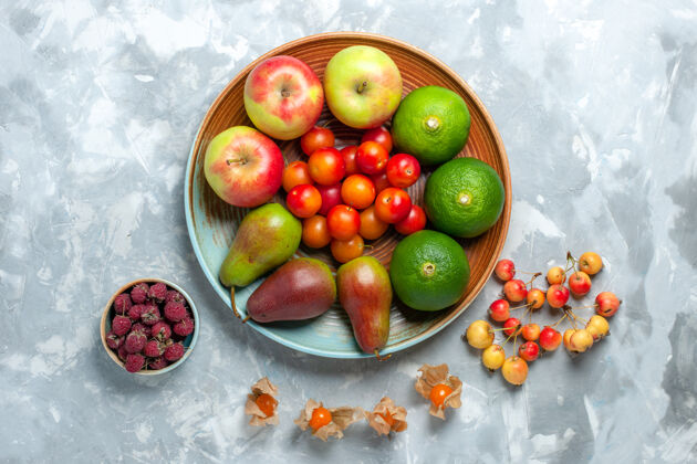 食品白色书桌上的水果组合俯视图苹果梨橘子李子苹果水果水果