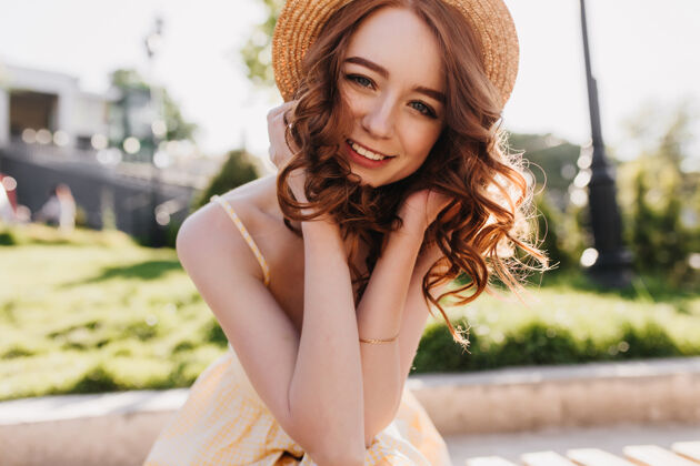 姜姜黄色头发的迷人女模特在大自然中摆出可爱的微笑戴草帽的幽默女孩在公园里享受拍照的户外照片卷发快乐漂亮