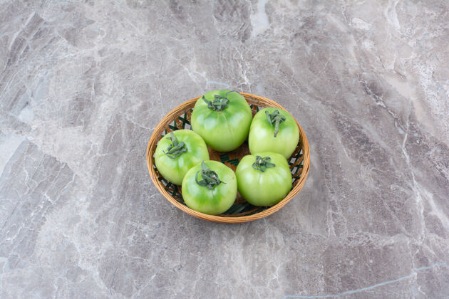 生的一堆绿色的西红柿放在陶瓷碗里食物西红柿天然