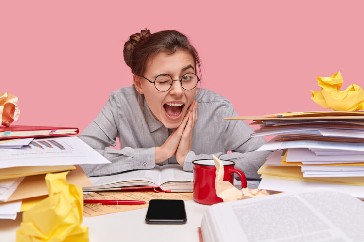 个性开朗的女生横视着眼睛 戴着圆眼镜 双手合十 在学习过程中玩得开心书呆子眼镜眼镜