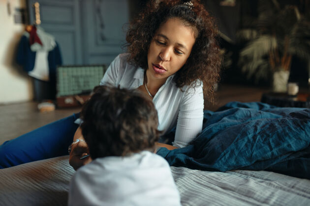 舒适母性 养育和家庭生活美丽的年轻西班牙裔母亲照顾她的小儿子横向画像交流女性关怀