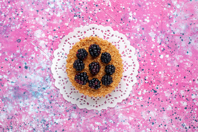 黑莓顶视图黑莓蛋糕浅粉色背景上的小水果蛋糕顶部蛋糕浅粉色