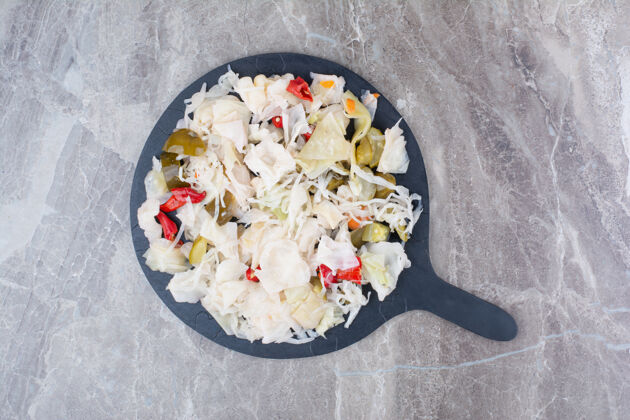 食品腌白菜和各种蔬菜放在深色盘子里酸的生的切丝