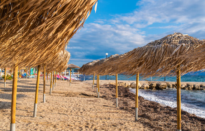 岛屿希腊科孚岛上的美丽海湾 海水清澈见底爱奥尼亚海滩的美丽景色 带着草伞 阳光明媚休息石头山