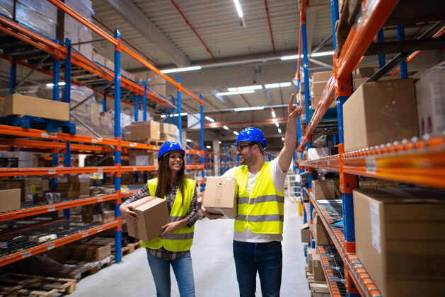 工人工人们在大型仓库中心搬运箱子和重新安置物品正面商品质量控制