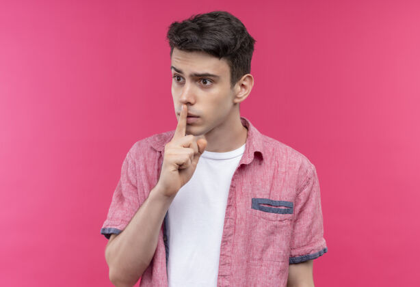 粉色严格的白人年轻人穿着粉色衬衫 在孤立的粉色背景上表现出沉默的姿态男人年轻沉默