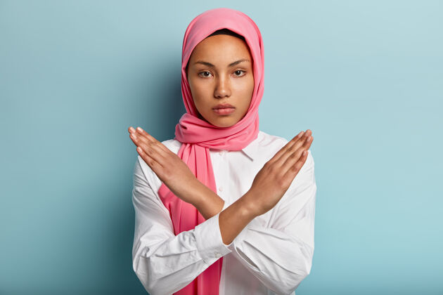 安全美丽严肃的阿拉伯女人戴着粉色的头巾 双手交叉在胸前推阿拉伯持有