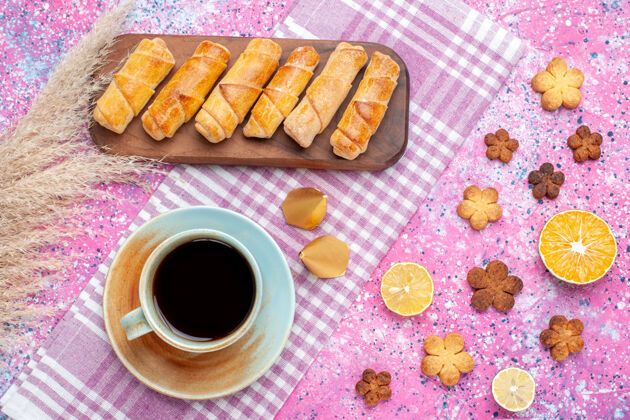 糖在粉红色的桌子上可以看到面包圈和饼干 还有一杯茶食物零食午餐