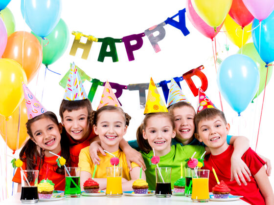 男孩一群穿着五颜六色衬衫的快乐的孩子在生日聚会上玩得很开心-被隔离在白色的地板上同学庆祝气球