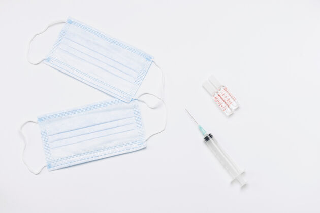 疫苗两个一次性医用口罩 刺针和白色背景的药瓶病毒注射器流感
