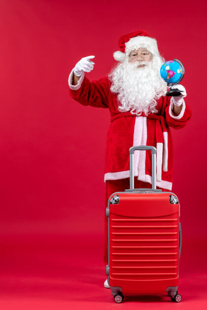 节日前视图的圣诞老人与包举行地球仪和准备旅行的红墙男人圣诞人