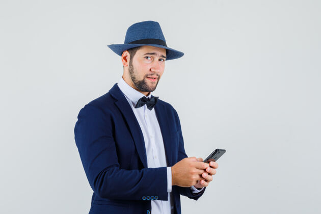 自信年轻人拿着手机 穿着西装 戴着帽子 看上去很自信 前视电话肖像西装