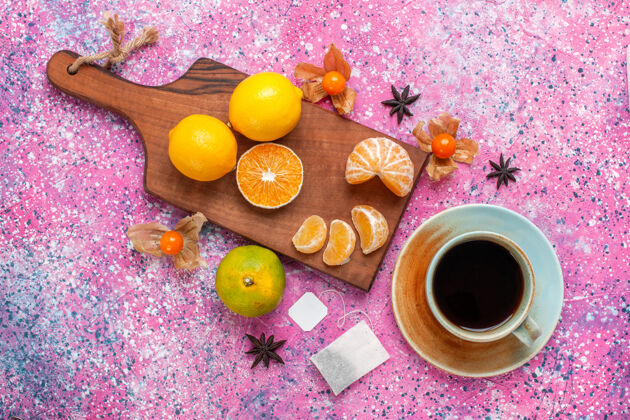柠檬在粉红色的表面上可以看到酸涩的新鲜橘子和柠檬以及一杯茶热带传统假日