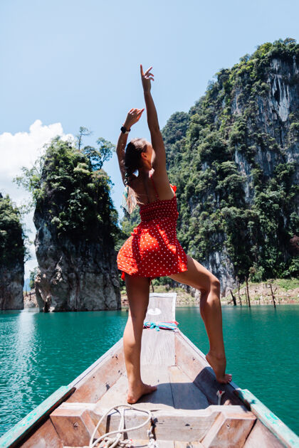 泻湖穿红色夏装的高加索女子在泰国亚裔船上度假 环游泰国湖泊冒险欢乐