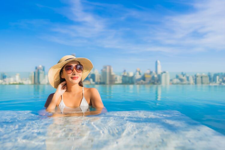 天际线美丽的亚洲年轻女子在户外游泳池周围放松 城市景色尽收眼底豪华高高