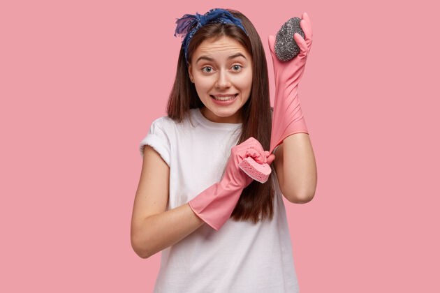 头巾高兴的白种年轻女子戴上橡胶手套 端上两块海绵 准备洗碗高兴害怕表情