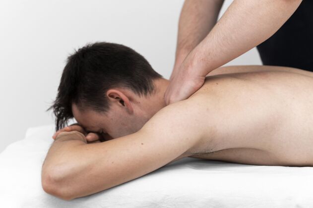 创伤理疗师为男性患者做背部按摩男人物理损伤