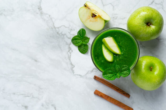 玻璃杯一杯青苹果健康冰沙放在新鲜青苹果旁边水果护理苹果酒