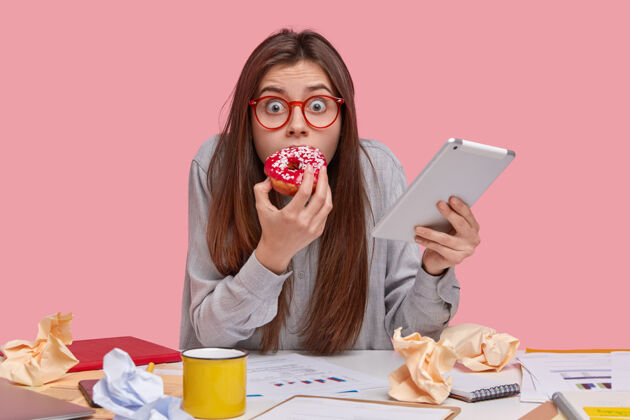 可怕害怕情绪化的女人 眼睛被 喜欢吃美味的甜甜圈 害怕因为糟糕的工作受到惩罚 携带现代触摸板可怕眼镜互联网