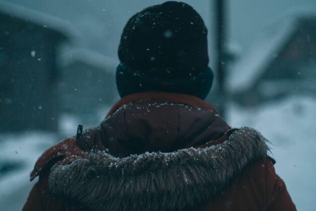 假日一个冬天穿着连帽外套和小豆豆的男人的后背冬天寒冷人