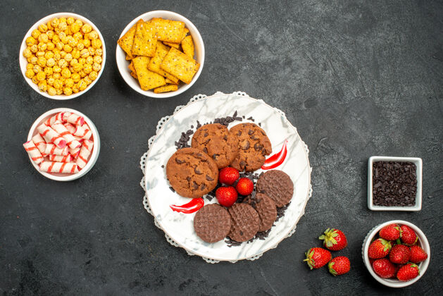 早餐俯瞰美味的巧克力饼干和不同的零食在黑暗的桌子上茶甜饼干菜盘子美食