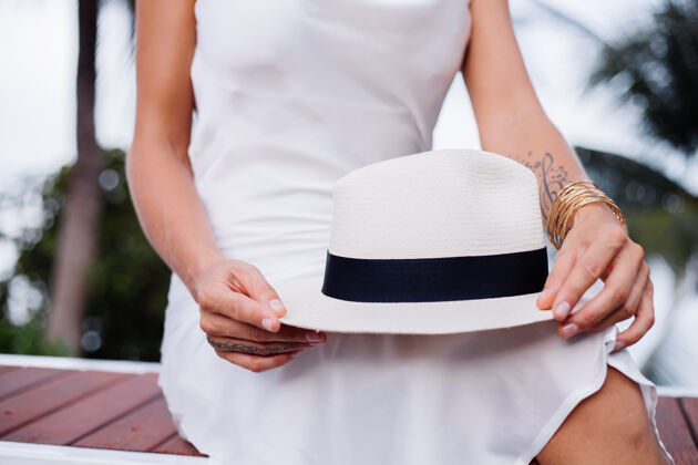 经典穿着丝绸合身连衣裙 戴着经典白帽子的近景女郎时尚优雅隐藏