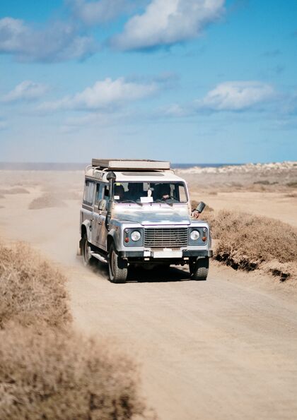 运动在沙漠道路上行驶的越野车的垂直方向单人西部汽车