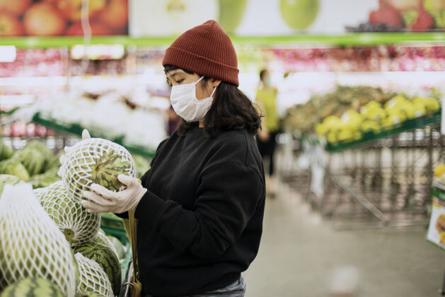 选择戴着医用口罩的妇女在冠状病毒大流行期间购买新鲜食品意识选择冠状病毒