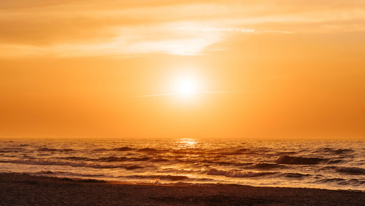 自然夏日沙滩上的橙色夕阳日落海浪自然