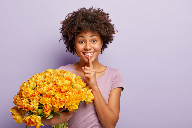 浪漫快乐的美国黑人妇女的肖像画以喜悦的表情做出沉默的手势 手持一大束春花发型T恤节日