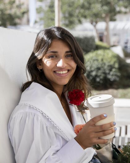 流行病带着咖啡杯和鲜花在户外微笑的女人冠状病毒杂货店咖啡