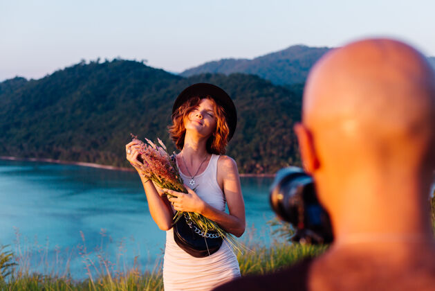 乐趣视频拍摄过程中的男子采取专业摄像机上的年轻时尚女博客度假热带景观数码微笑照片