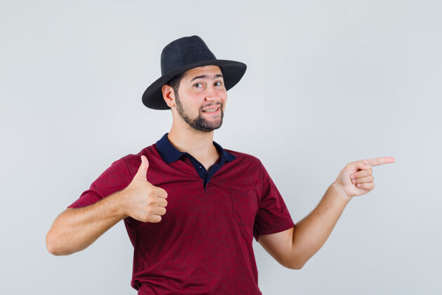 人身穿t恤的年轻男子 戴着帽子 一边竖起大拇指 一边满意地看着前方时尚肖像展示