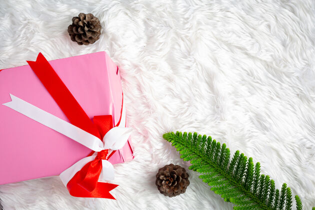 礼物白色皮草织物上有缎带的粉色礼盒光泽快乐圣诞快乐