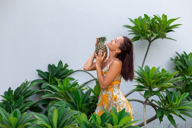 泰国身着黄色夏装 手持菠萝的快乐亚洲微笑女人的画像自然热带肖像