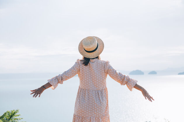 放松快乐的女人在夏天可爱的裙子和草帽度假与热带异国情调的看法热带自然快乐