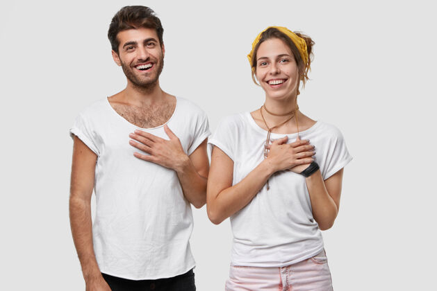 姿势高兴的男女双手放在胸前 面带微笑 对亲人的帮助表示感谢积极女士快乐