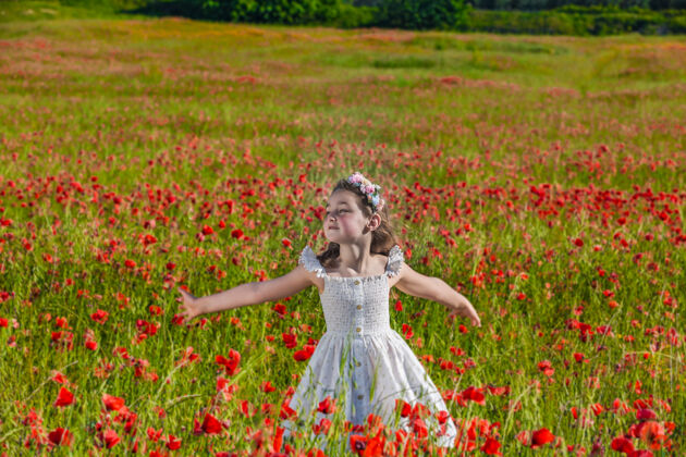 服饰无忧无虑的小女孩在盛开的草地上玩耍田野季节花